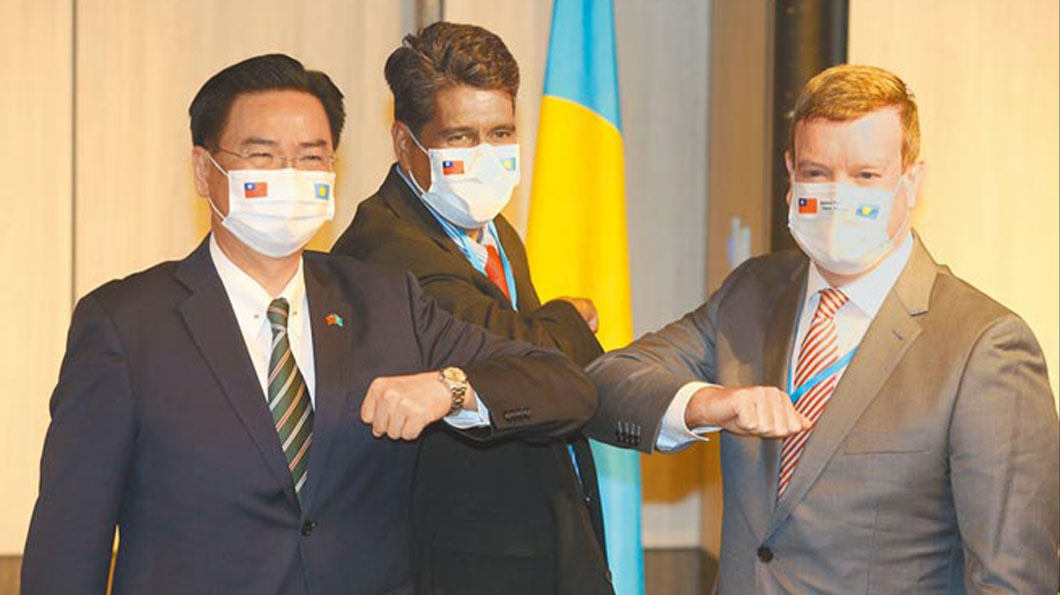 帛琉總統惠恕人（中）來臺，29日舉行國際記者會後，與同行的美國駐帛琉大使倪約翰（右），以及外交部長吳釗燮（左）一同碰手臂合影。（圖片擷取自〈美大使隨行，專家指具戰略意涵〉，中時電子報，2021年3月30日。）