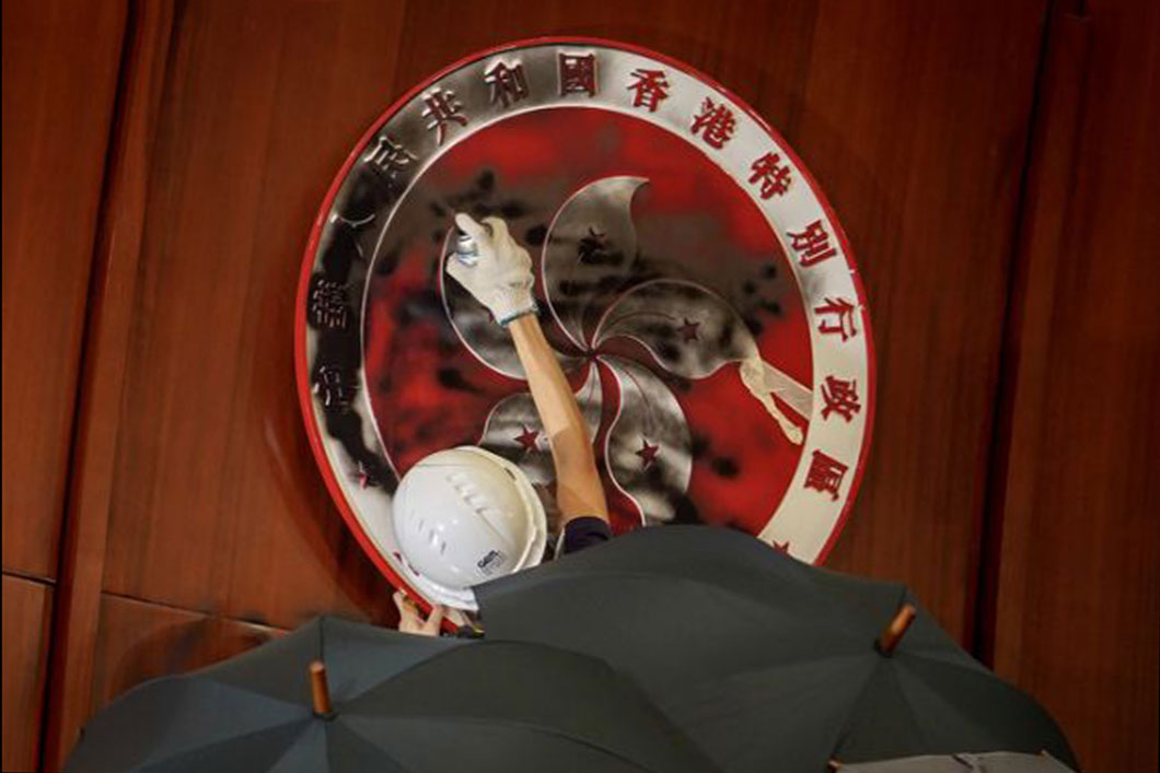 2019年7月1日，反修例暴亂的暴徒衝入香港特區立法會，大肆破壞立法會的設施，圖中的暴徒將香港特區區徽塗黑。